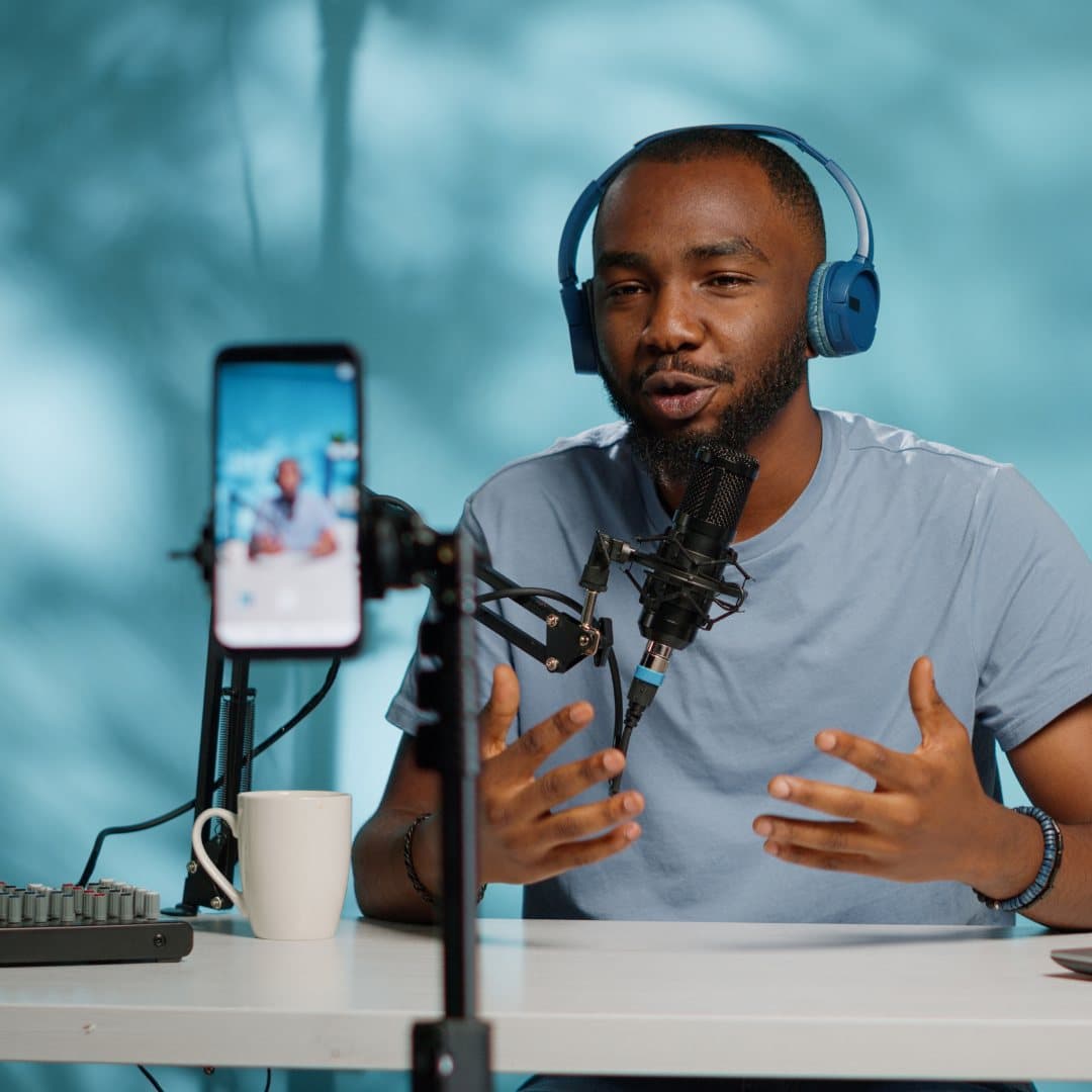 A creator recording with a microphone and phone