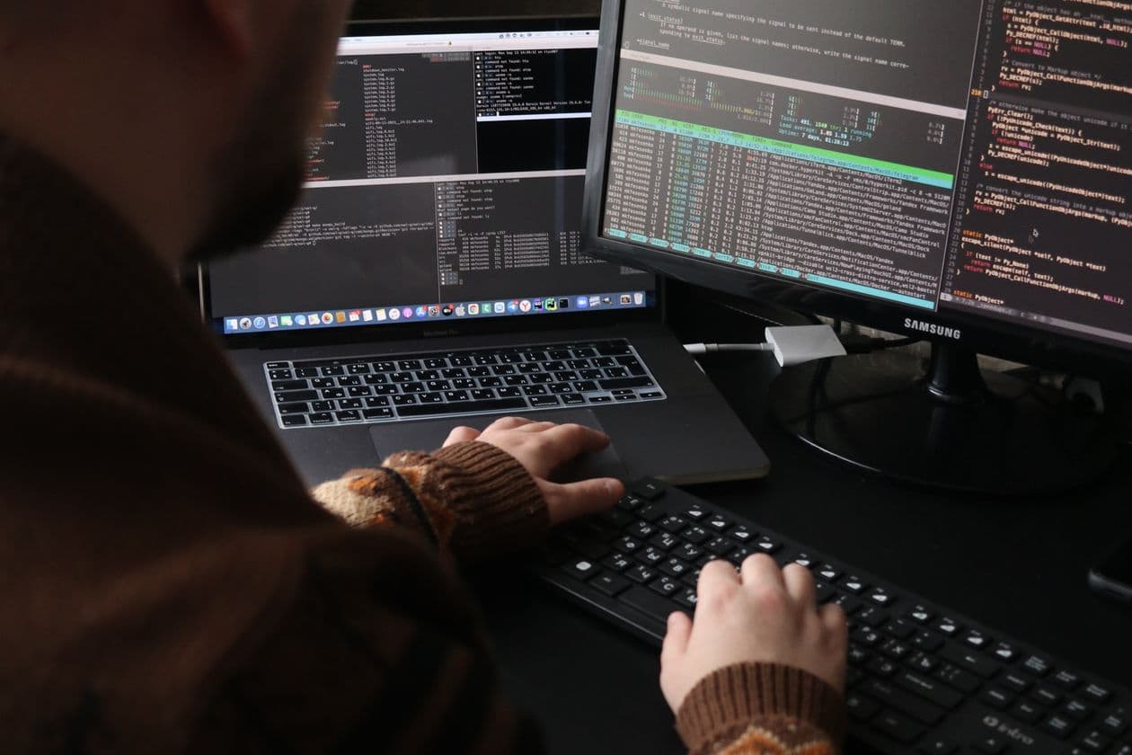 Hands at a keyboard with code on screen